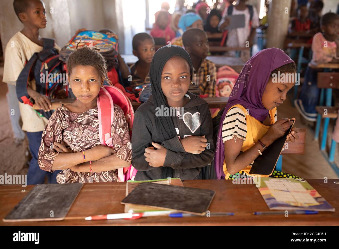 Das Senou Camp liegt am südlichen Rand von Bamako, Malis Hauptstadt. Es ist eines von acht solchen informellen Camps in der ganzen Stadt und allein beherbergt es 223 Familien und etwas mehr als 1.000 Binnenvertriebene. Die hier lebenden Familien sind vor Gewalt und Aufstand im Norden und in den zentralen Teilen des Landes geflohen. Da die meisten von ihnen kein Einkommen oder eine regelmäßige Nahrungsquelle haben, ist der Hunger eine tägliche Herausforderung und die Unterernährung der Bevölkerung ist nach wie vor weit verbreitet. Hier schreiben Kinder auf Kreideschiefer in der einzigen Grundschule des Lagers, die von Frau Asmatou Coulibably unterrichtet wurde. Stockfoto