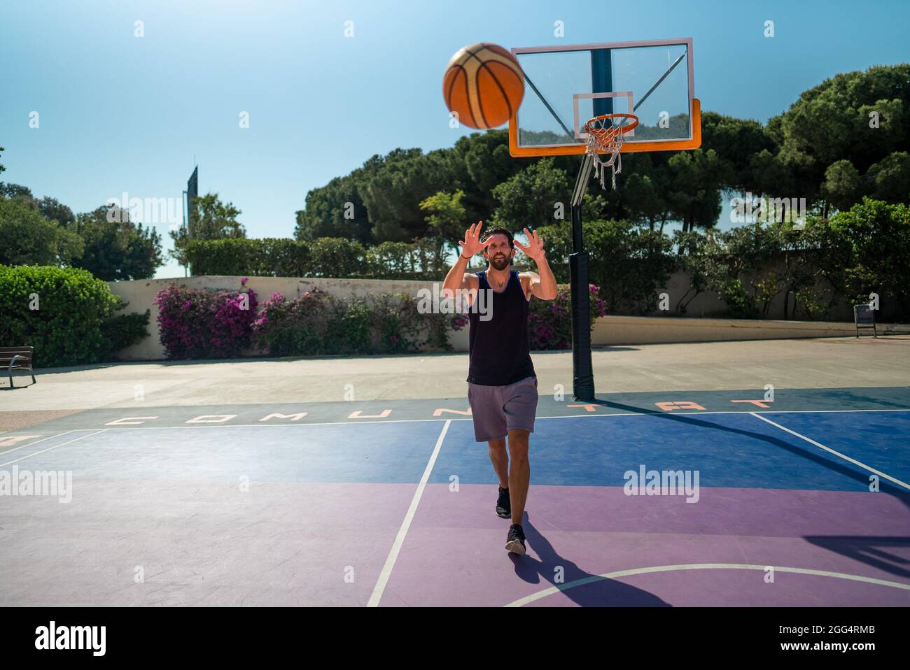 Ein Basketballspieler fängt einen Ball, der zu ihm geworfen wird. Pass im Spiel. Stockfoto