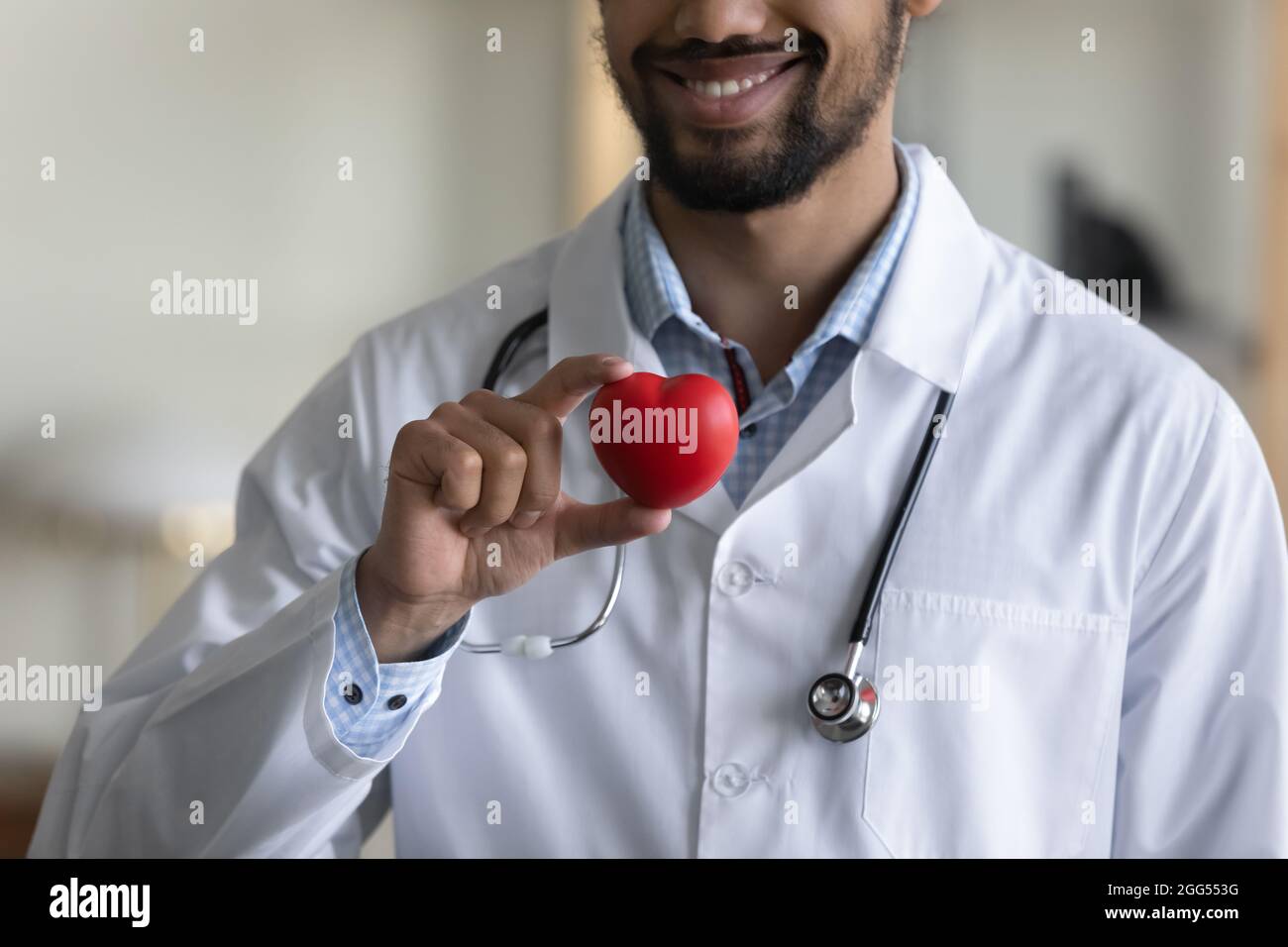 Nahaufnahme des tausendjährigen afrikanischen Arztes mit einer Herzfigur. Stockfoto