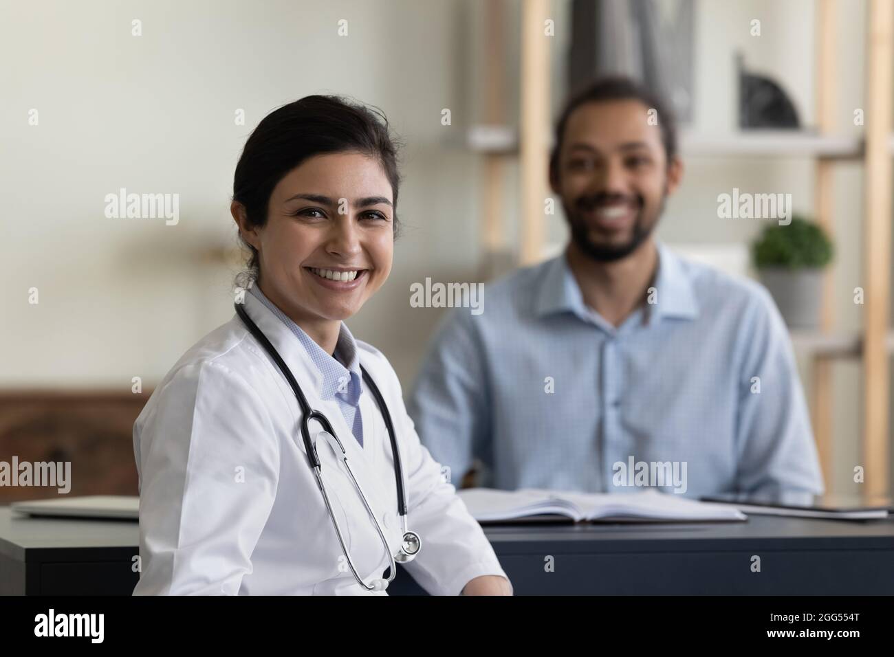 Porträt eines lächelnden indischen Arztes mit afrikanischem Patienten. Stockfoto