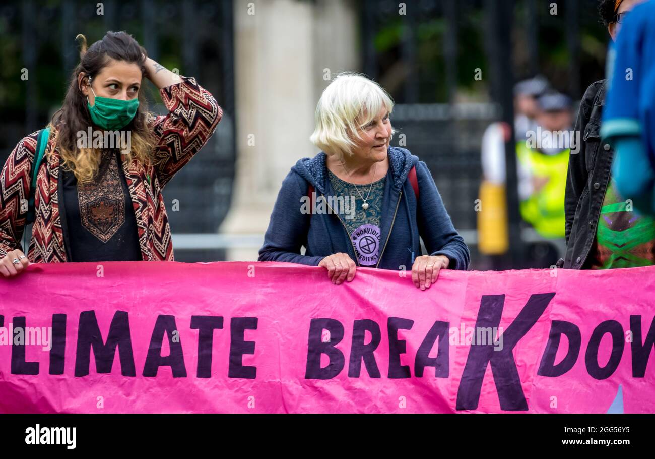 Demonstranten, die sich gegen den Klimawandel aufmachen, mit einem Banner vor dem britischen parlamentsgebäude in London, Großbritannien. Stockfoto