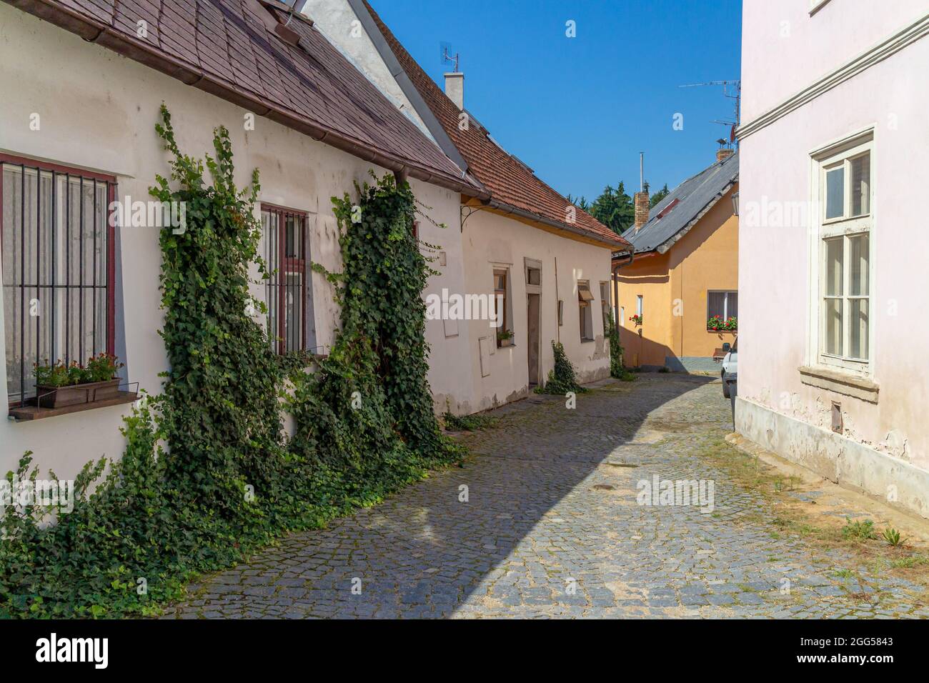 Schmale Gasse in einer kleinen tschechischen Stadt mit Kopfsteinpflaster und typischen südböhmischen Häusern und Dachdecken Stockfoto