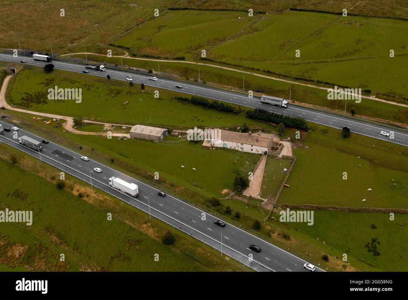 Luftbild des Colour Pop der berühmten Stott Hall Farm in der Mitte der Autobahn M62 Stockfoto