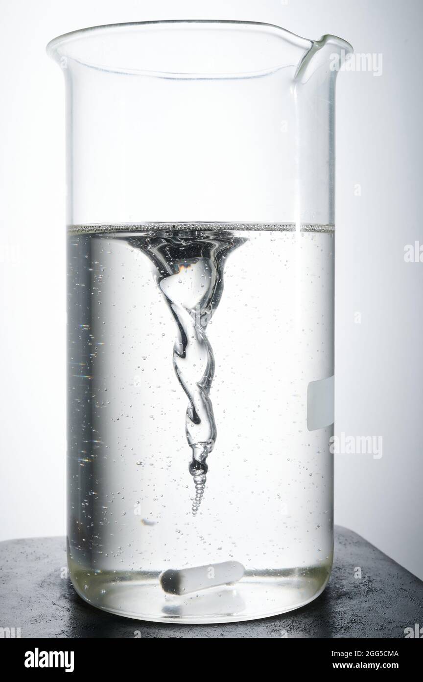Thema „Durchführung chemischer Experimente“. Transparente Flüssigkeit in Glas auf Magnetmischer Stockfoto