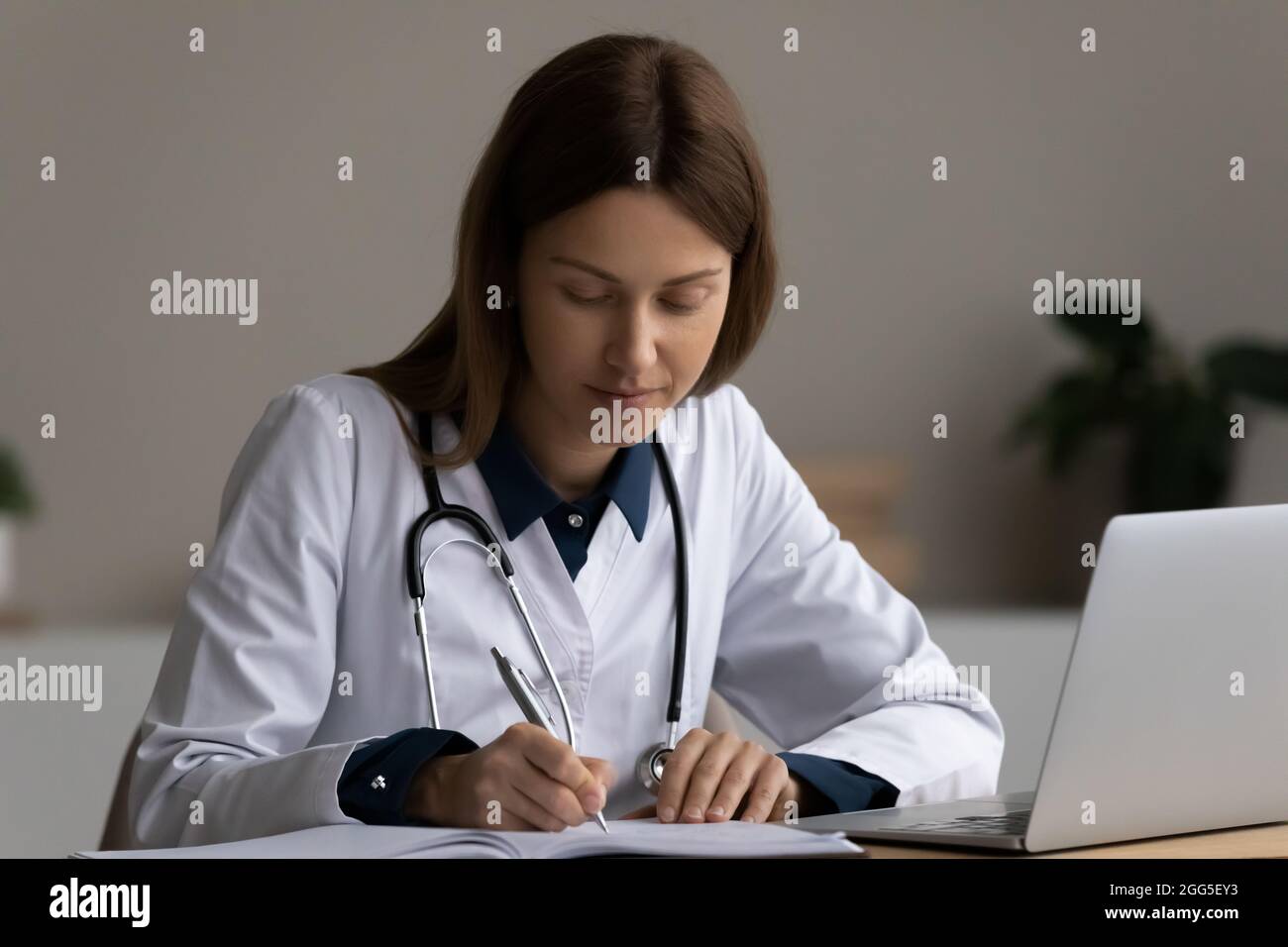 Konzentrierter junger Arzt, der in einem modernen Büro arbeitet. Stockfoto