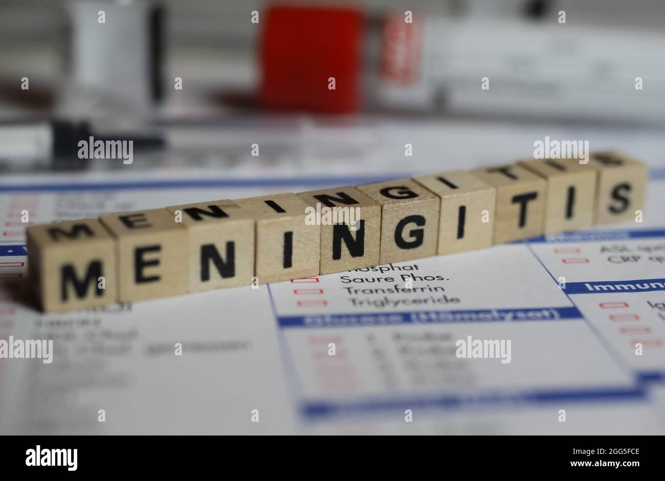 Viersen, Deutschland - 1. Juni. 2021: Nahaufnahme des Wortes Meningitis auf dem Laborausschreibungsschein mit Spritze und Fläschchen Stockfoto