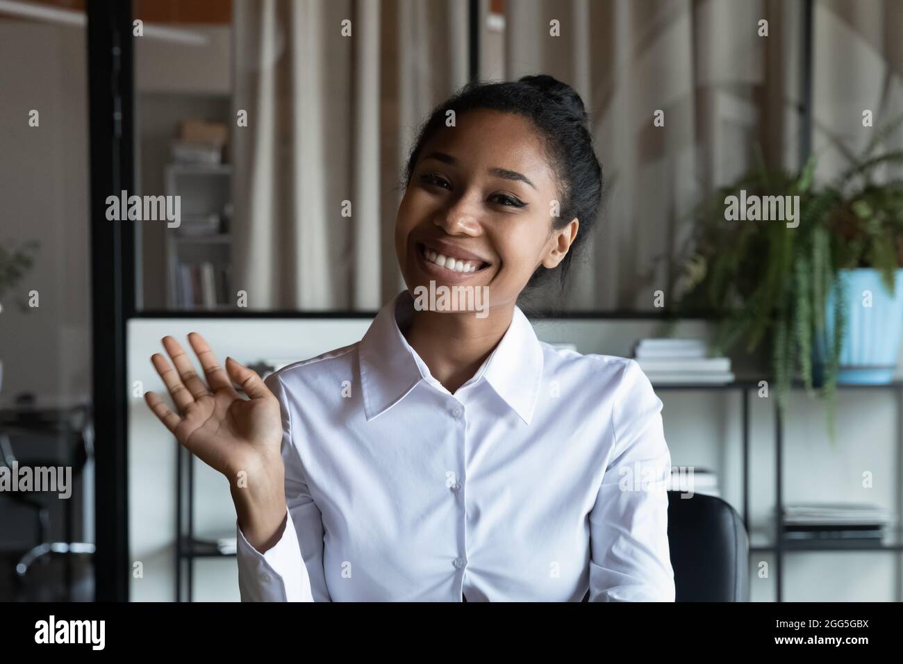 Porträt mit lächelnder afroamerikanischer Geschäftsfrau, die die Hand winkt Stockfoto