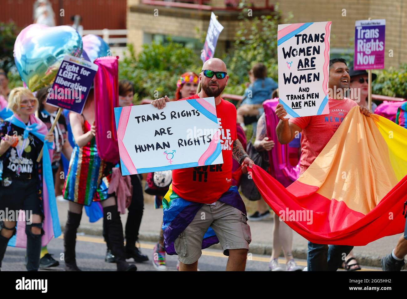 Hastings, East Sussex, Großbritannien. 29. August 2021. Die Pride Parade 2021 kehrt am Sonntag an den Feiertagen zum Thema „Zurück in die 80er Jahre“ in die Küstenstadt Hastings in East Sussex zurück. Ein Mann hält ein Banner hoch, auf dem die Aufschrift Trans-Rechte sind Menschenrechtszeichen steht. Foto-Kredit: Paul Lawrenson /Alamy Live Nachrichten Stockfoto