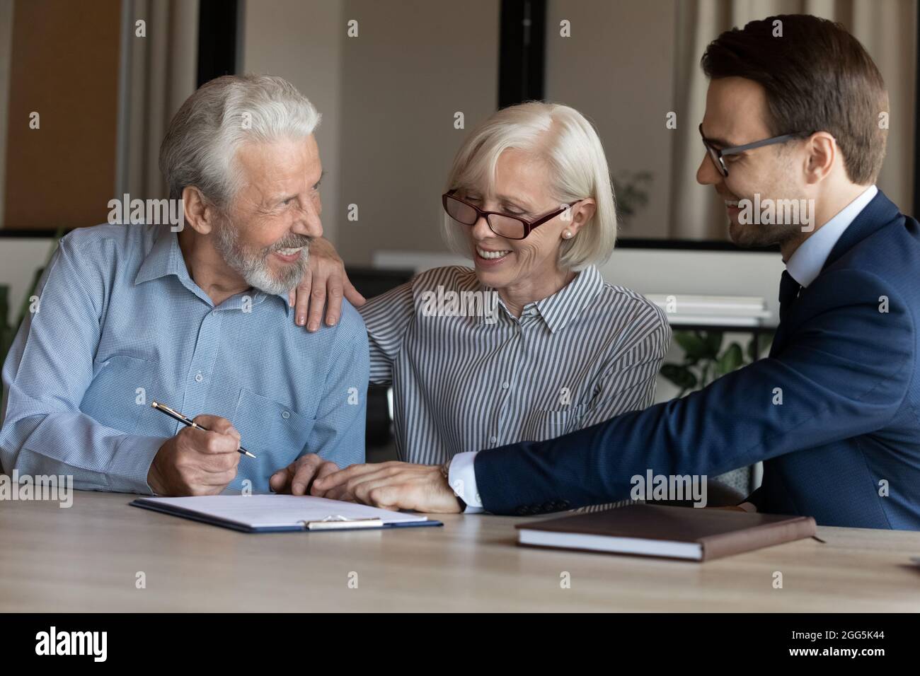 Aufgeregt reifes Paar Unterzeichnung Vertrag, macht viel bei der Sitzung Stockfoto