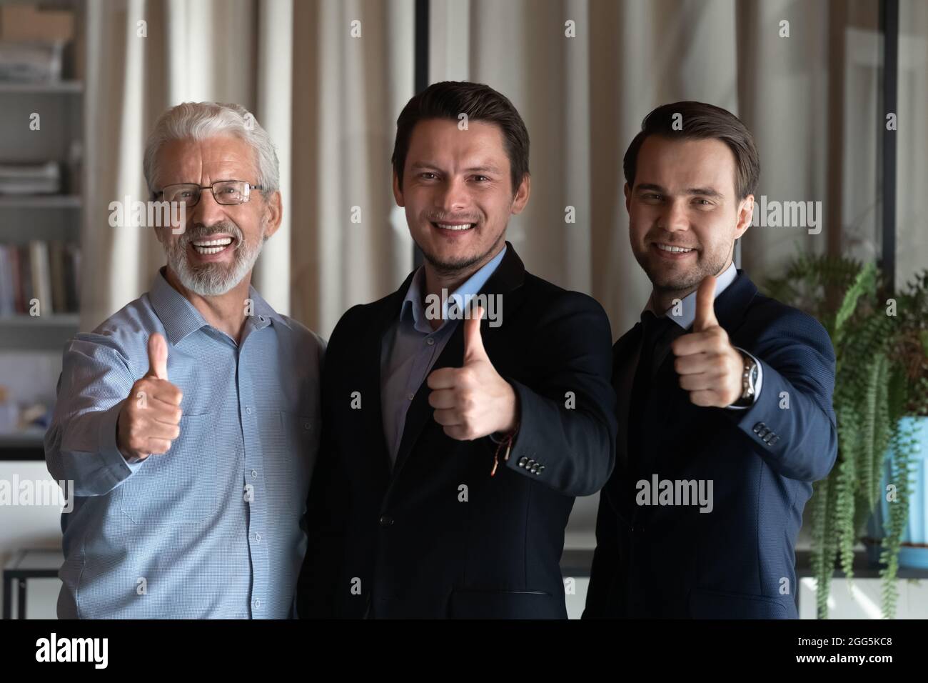 Porträt eines lächelnden, erfolgreichen Mitarbeiterteams, das Daumen nach oben zeigt Stockfoto