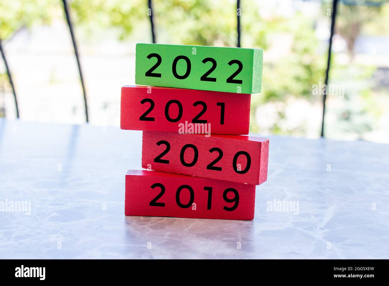 Die Worte 2019, 2020, 2021 und 2022 stehen auf den übereinander gestapelten Holzblöcken. Neues Jahr 2022 kommt Konzept. Stockfoto