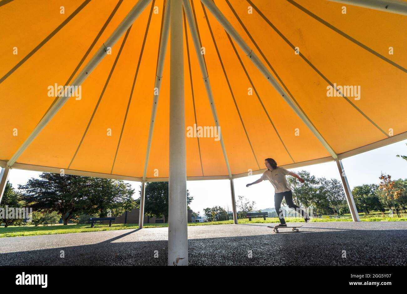 Carrigaline, Cork, Irland. August 2021. Joshua O Drisceoil skates under the Canopy of the New Bandstand at the Community Park in Carrigaline, Co. Cork, Ireland. - Credit: David Creedon / Alamy Live News Stockfoto