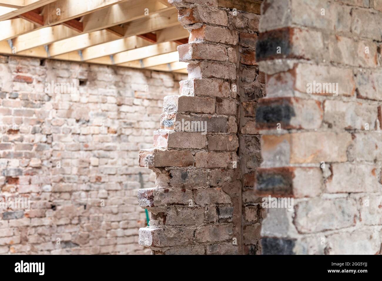 Teilweise entfernte Backsteinmauer bei einer Renovierung eines alten Backsteinhauses Stockfoto