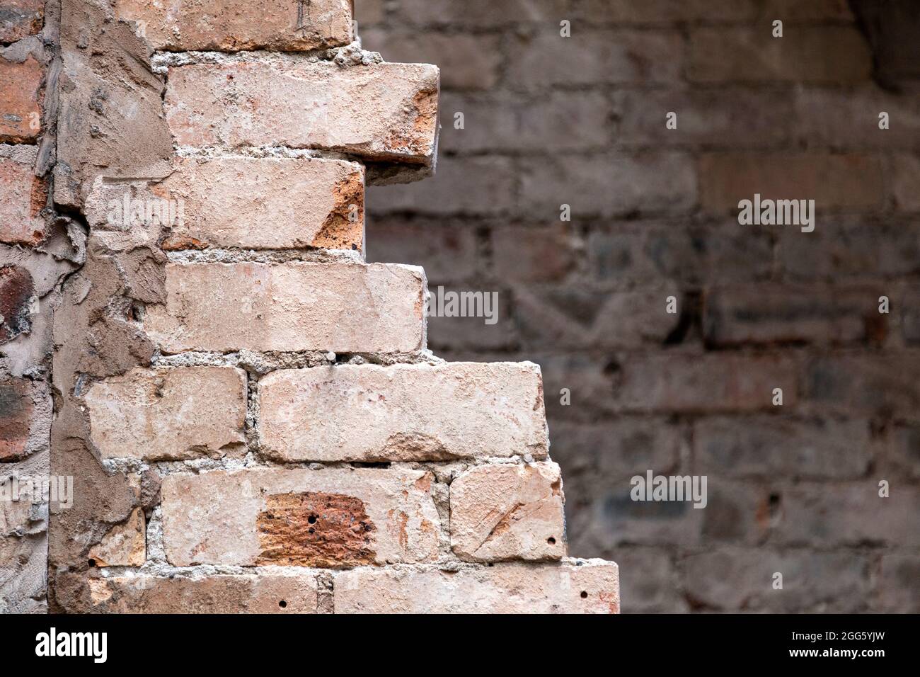 Teilweise entfernte Backsteinmauer bei einer Renovierung eines alten Backsteinhauses Stockfoto