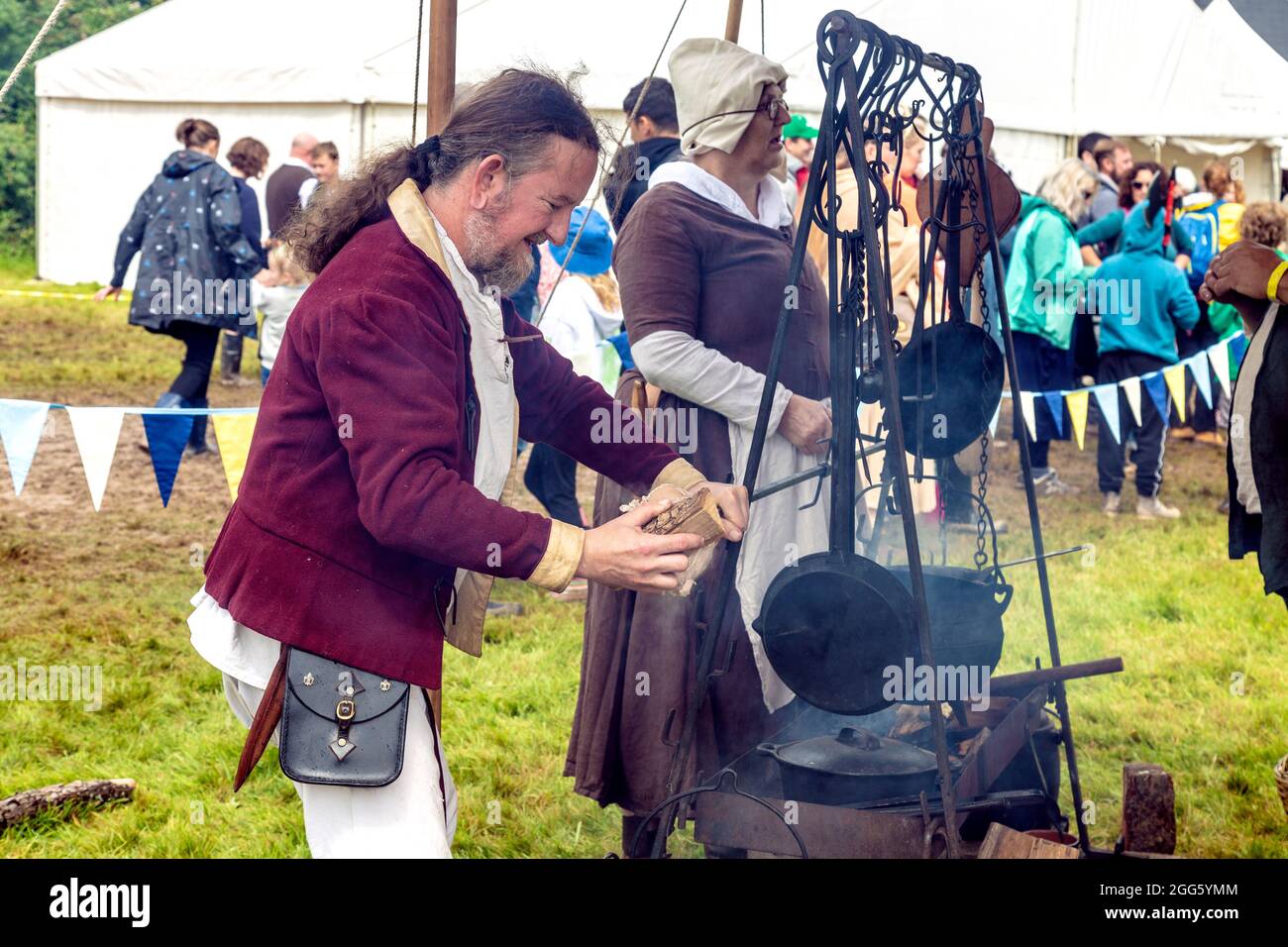 8. August 2021 - ein Mann, der ein Stück Fleisch auf den Bratspieß in der mittelalterlichen Küche (Jane’s Medieval Kitchen) beim Medieval Festival Loxwood J stielt Stockfoto