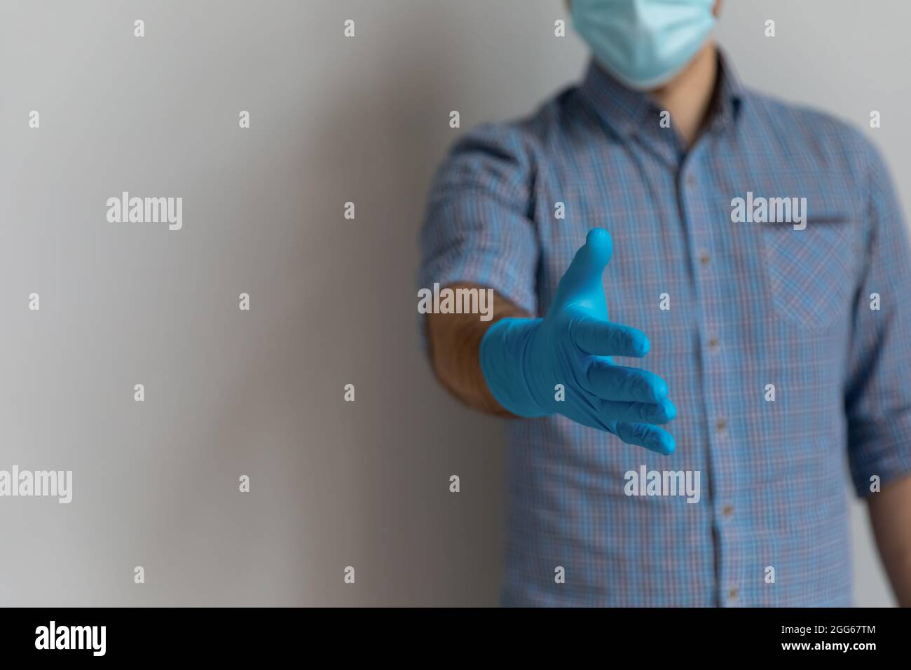 Mann mit medizinischer Gesichtsmaske und blauen Latex-Gummihandschuhen Stockfoto