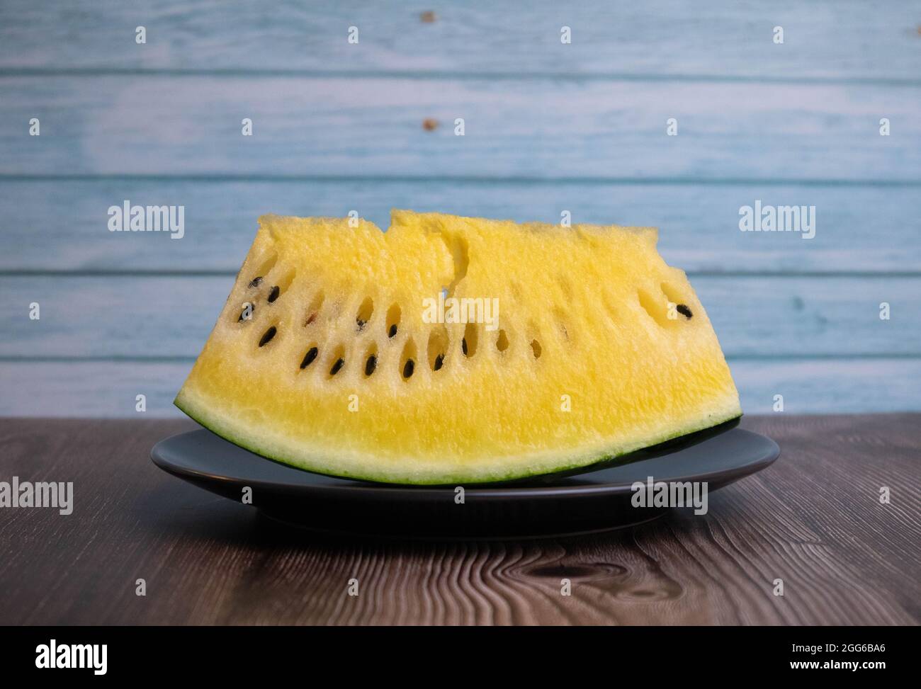 Gelbe Wassermelone auf schwarzem Teller, anders denken Stockfoto