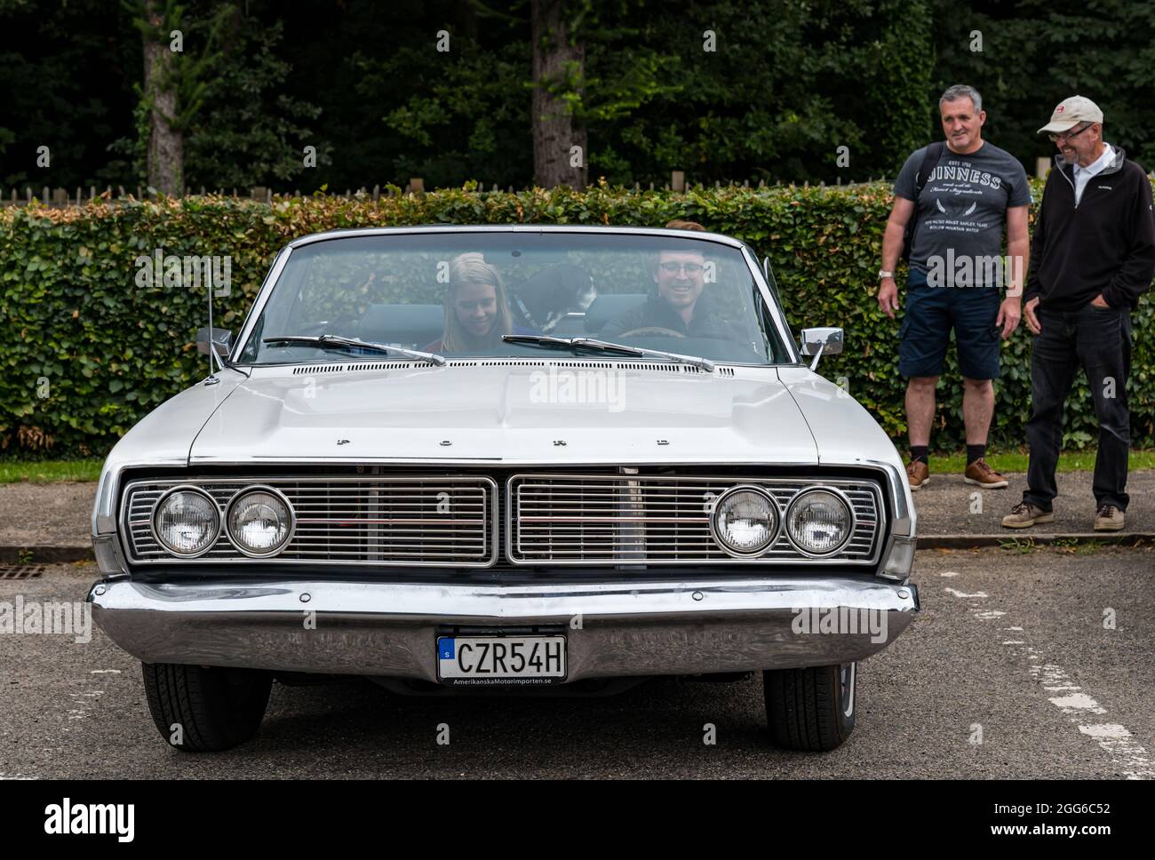 Newhailes, Musselburgh, East Lothian, Schottland, Großbritannien, August 2021. Rallye Klassenwagen: Eine Outdoor-Veranstaltung mit dem Namen Carhailes findet statt, bei der Oldtimer ausgestellt werden. Im Bild: Eine junge schwedische Coulpe kommt in einem Vintage-Gas-fressenden amerikanischen Ford Galaxy Auto Stockfoto