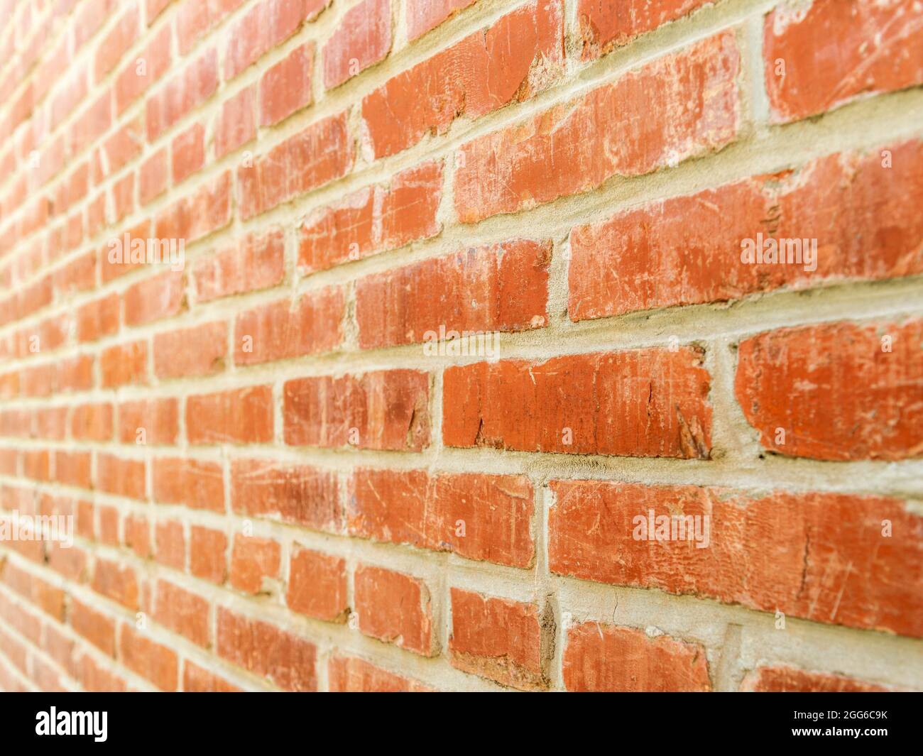 Abnehmende perspektivische Nahaufnahme von rechts nach links der roten Ziegelwand Stockfoto