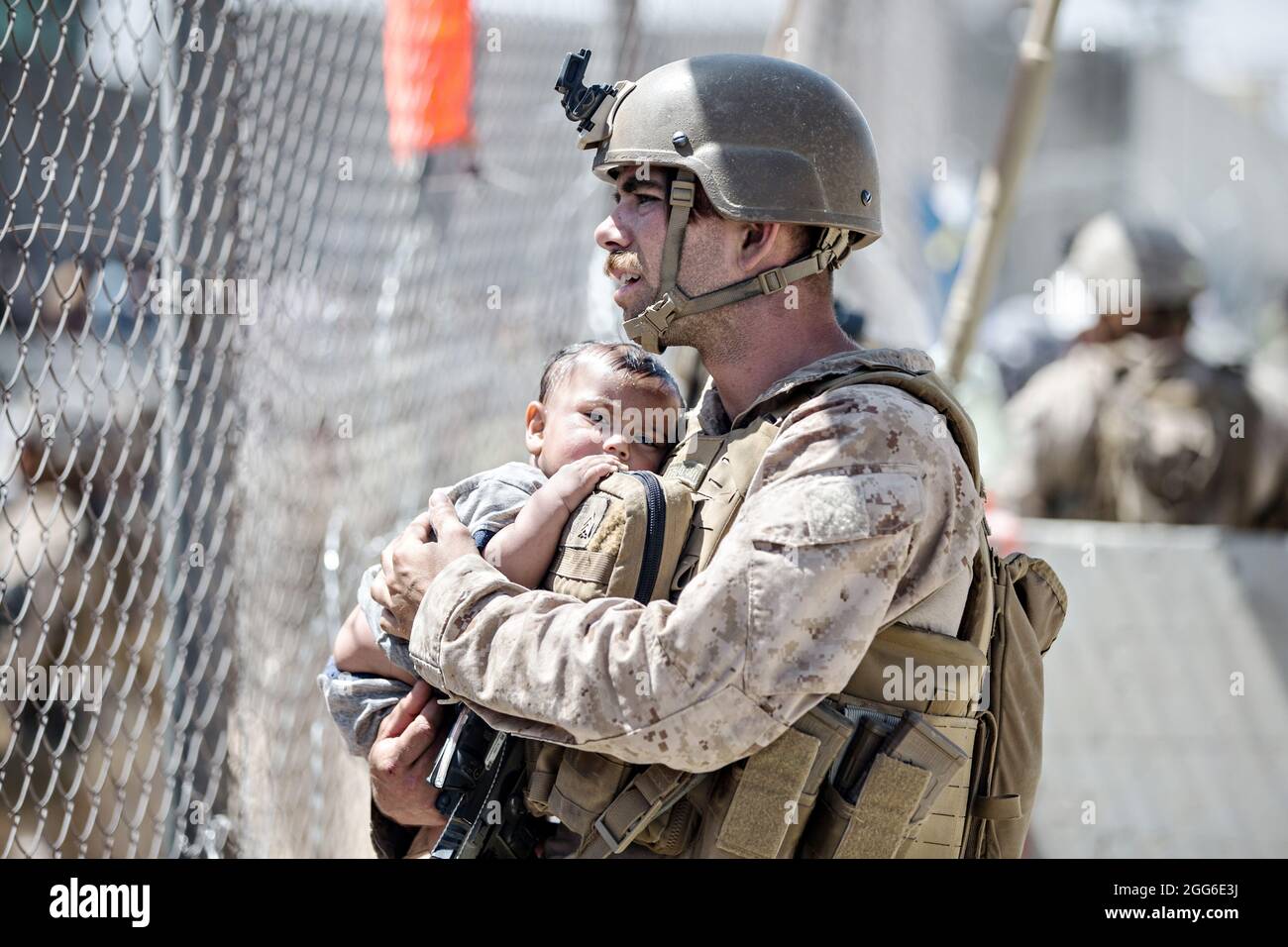 Kabul, Afghanistan. August 2021. Eine US-Marine mit dem Krisenreaktionsteam der Special Purpose Marine Air-Ground Task Force beruhigt ein Kleinkind, das auf die Evakuierung am Hamid Karzai International Airport wartet, während der Operation Allies Refuge am 28. August 2021 in Kabul, Afghanistan. Quelle: Planetpix/Alamy Live News Stockfoto