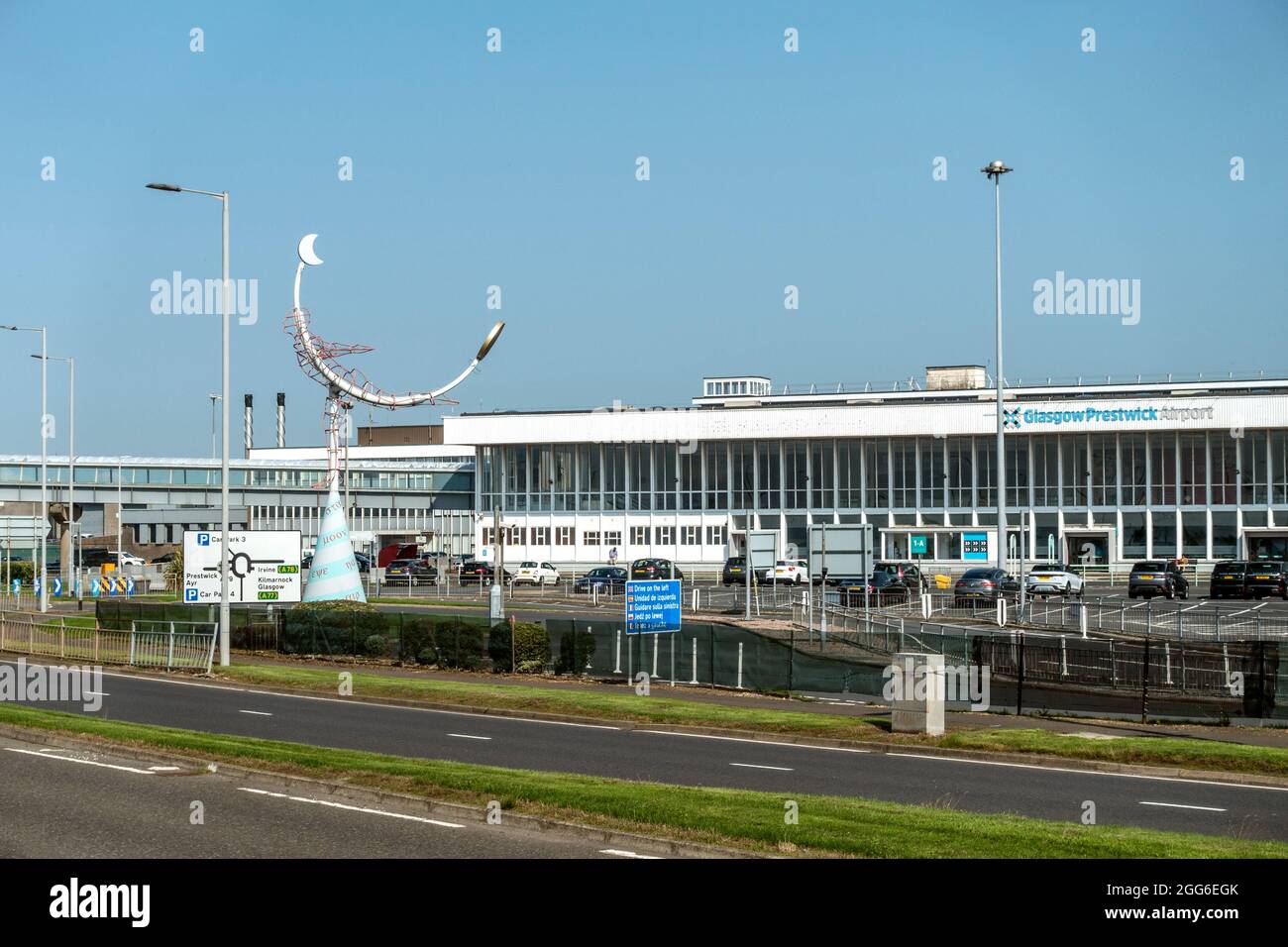 Glasgow Prestwick Airport, Außen- und Eingangsbereich; Schottland, mit der Statue Celestial Navigator (1997) von Carole Grey. Fünfsprachiges Laufwerk auf linkem Schild. Stockfoto