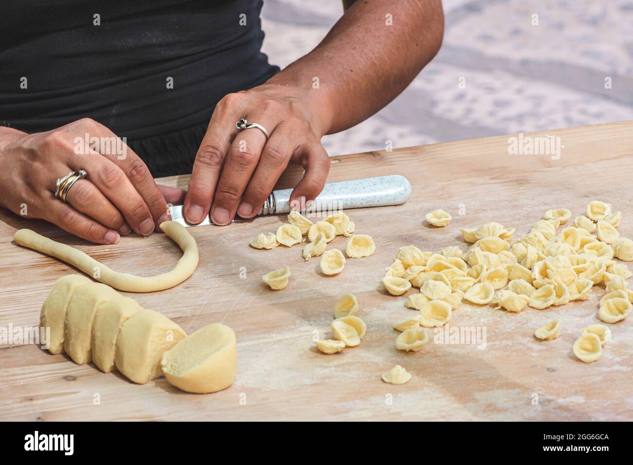 Hände der Frau, die in der Straße von Bari Altstadt orecchiette oder orecchietta, mit Hartweizen und Wasser, handgemachte Pasta typisch für Apulien Stockfoto