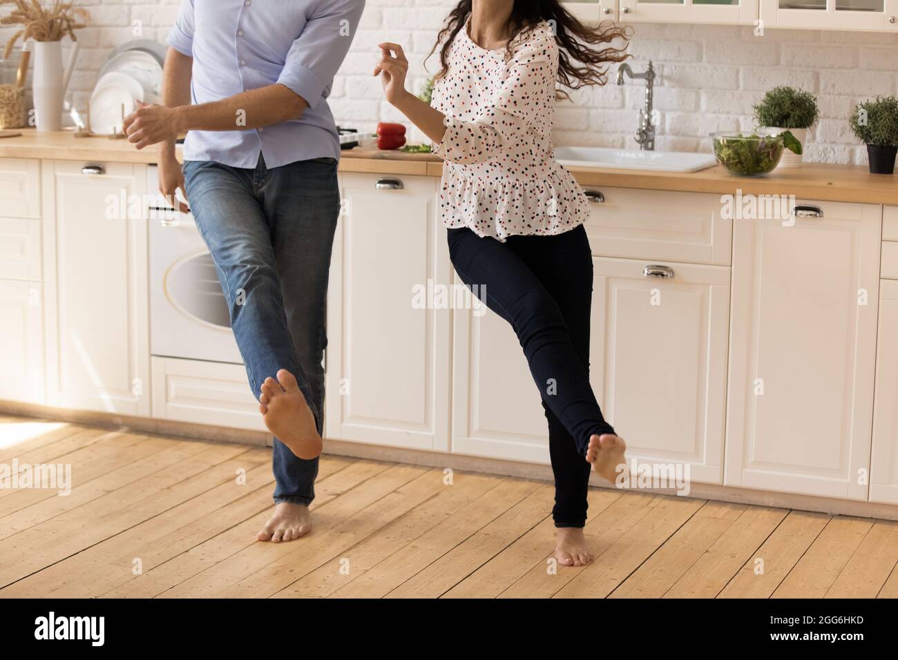 Konzentrieren Sie sich auf barfuß Beine des glücklichen jungen Familienpaares tanzen. Stockfoto