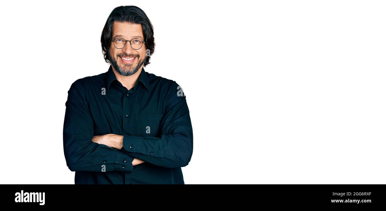 Mittlerer Alter kaukasischen Mann trägt Freizeitkleidung und Brille glücklich Gesicht lächelnd mit gekreuzten Armen Blick auf die Kamera. Positive Person. Stockfoto