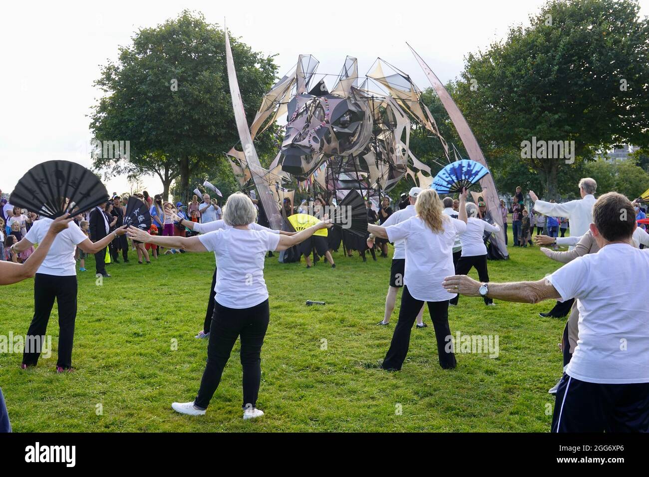 Plymouth, Großbritannien. 29.. Juli 2021. „The Hatchling“, ein Marionettendrachen, und ein Teil der Mayflower 400-Feierlichkeiten trifft eine Gruppe, die Tai Chi praktizert - und will mitmachen! Kredit: Julian Kemp/Alamy Live Nachrichten Stockfoto