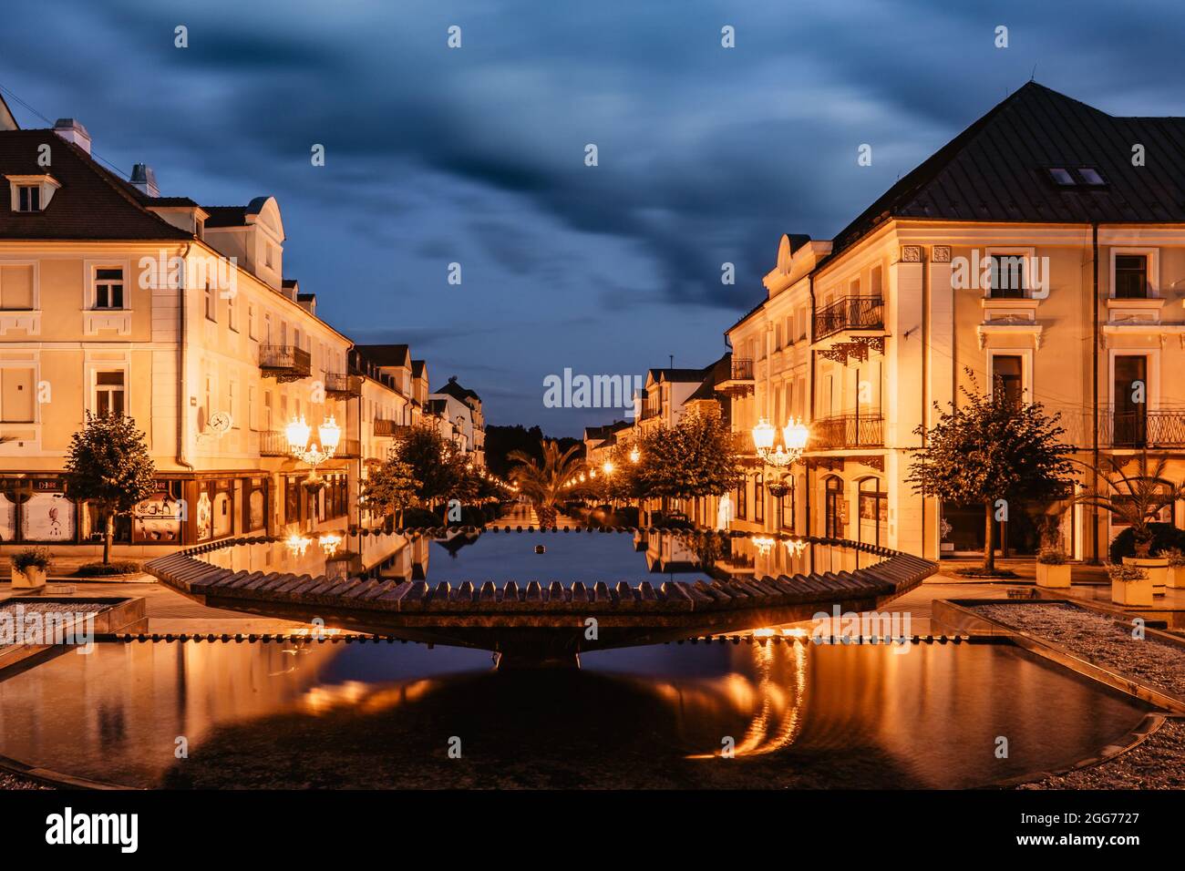 Brunnen in Frantiskovy Lazne bei Sonnenuntergang, Tschechische Republik.schöne Kurstadt in Westböhmen, Thermalgebäude mit typischer gelber Fassade Stockfoto
