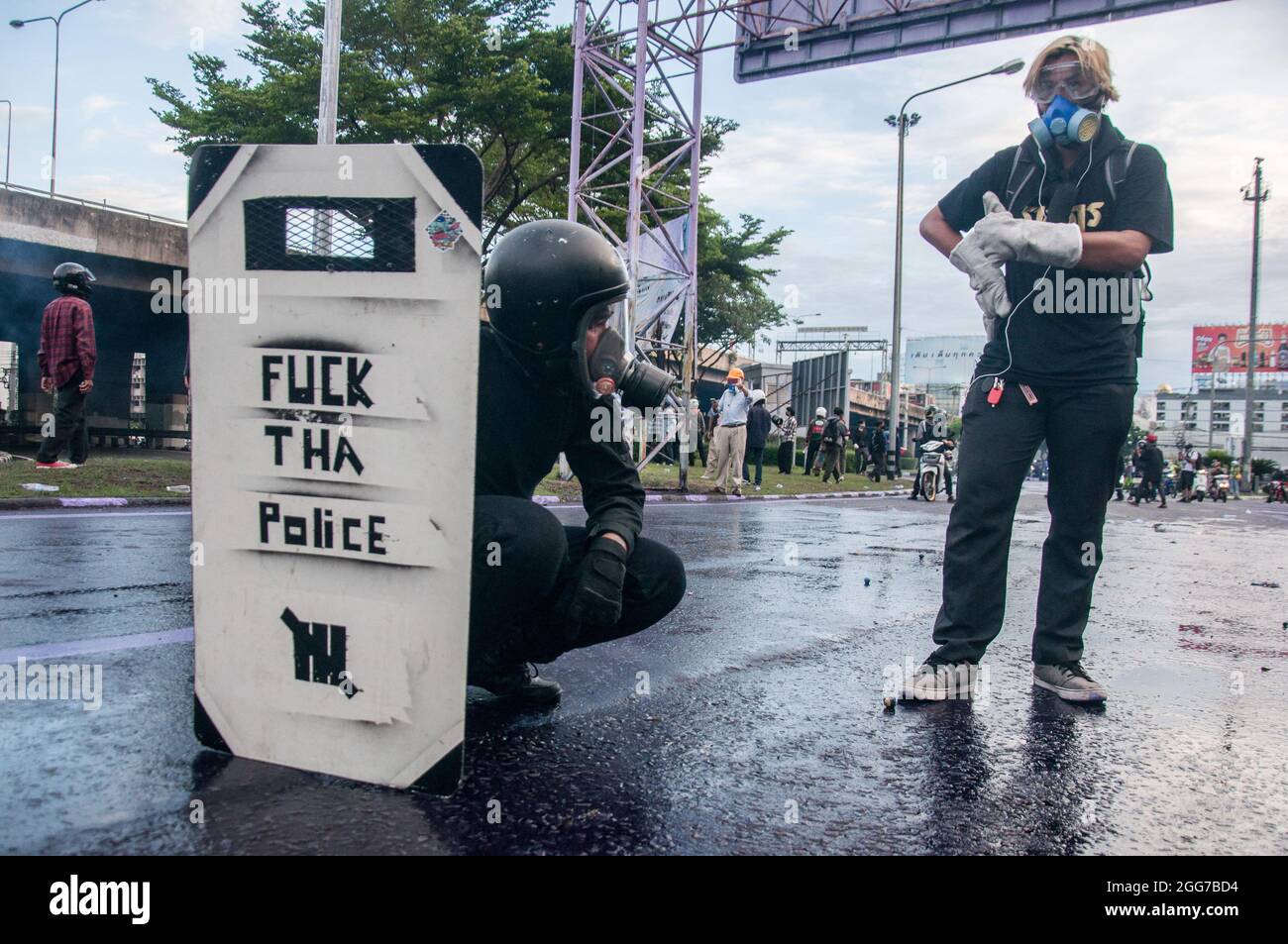 Bangkok, Thailand. August 2021. Ein Protestler nimmt während der Demonstration eine Abdeckung hinter einem handgefertigten Schild. Tausende von regierungsfeindlichen Demonstranten fuhren ihre Fahrzeuge und blasse Hörner in einem „Car Mob“-Konvoi, in dem sie den Rücktritt von Prayut Chan-O-Cha, dem Premierminister Thailands, wegen des Scheiterns der Regierung bei der Bewältigung der COVID-19-Krise forderten. An einem Abend an der Kreuzung von DIN Daeng versammelten sich Hunderte regierungsfeindlicher Demonstranten von „Car Mob“ an der Kreuzung von DIN Daeng und kollidierten mit den Polizisten. Kredit: SOPA Images Limited/Alamy Live Nachrichten Stockfoto