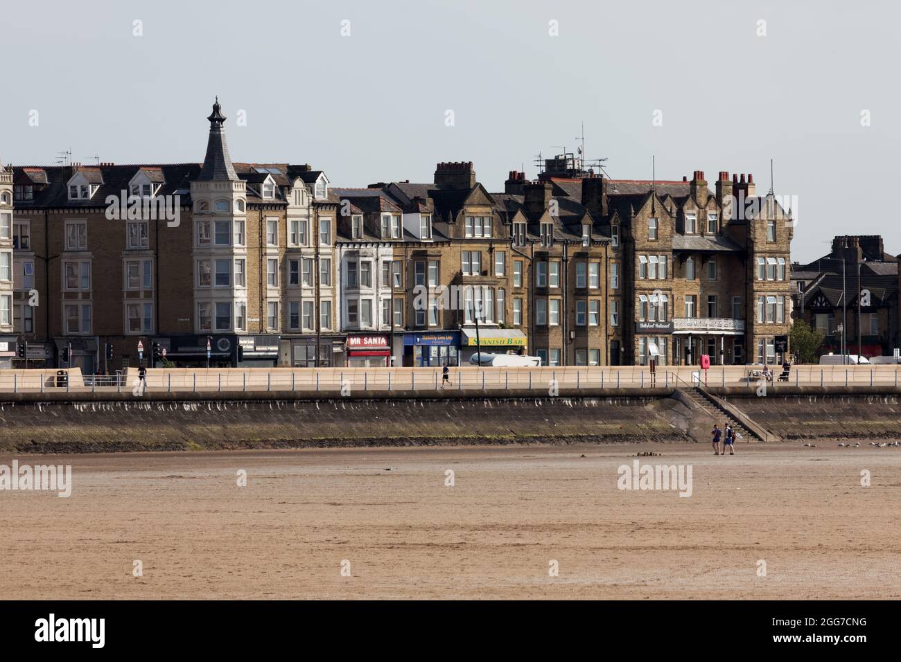 Blick über den Strand auf Gebäude entlang der Promenade in Morecambe Stockfoto