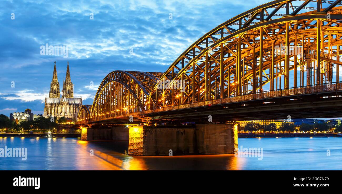 Skyline der Kölner Domstadt und Hohenzollernbrücke mit Rhein in Deutschland bei Dämmerungs-Panorama-Nacht Stockfoto