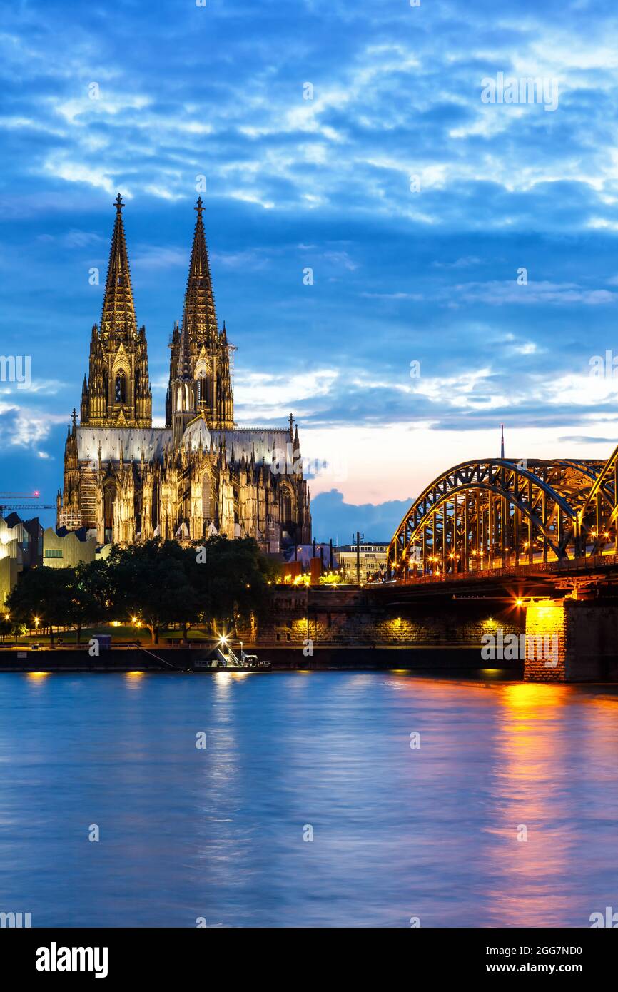 Skyline der Kölner Domstadt und Hohenzollernbrücke mit Rhein in Deutschland bei Dämmerung Porträtformat Nacht Stockfoto