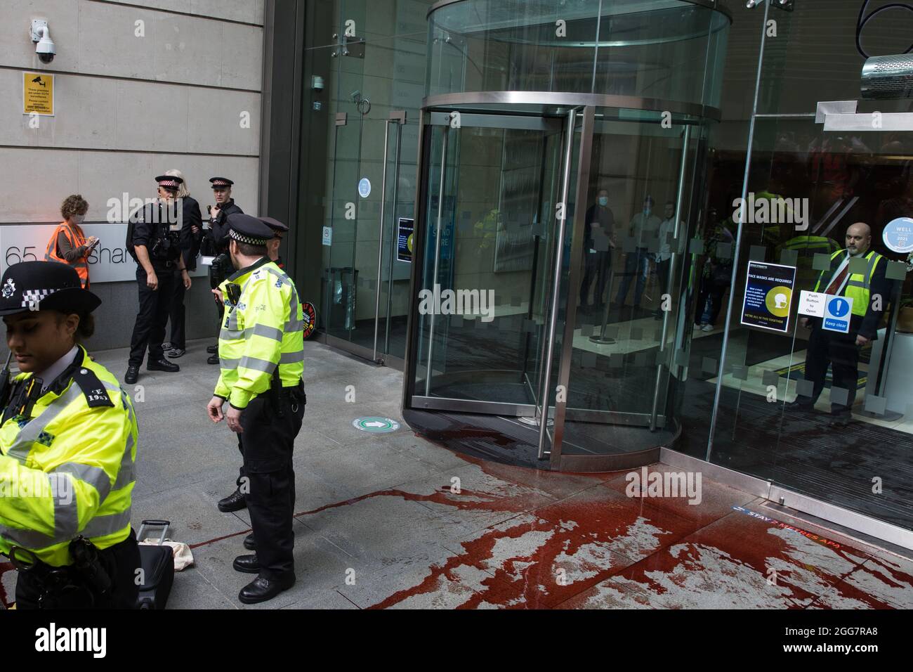 London, Großbritannien. August 2021. Die Polizei der Stadt London verhaftete einen Umweltaktivisten vor dem Extinction Rebellion, der gefälschtes Blut vor den Büros der Anwaltskanzlei Debevoise & Plimpton LLP während eines Blutgeldmarsches durch die City of London verbreitete. Extinction Rebellion beabsichtigte, Finanzinstitute, die Projekte mit fossilen Brennstoffen finanzieren, insbesondere im globalen Süden, sowie Anwaltskanzleien und Institutionen, die diese Projekte unterstützen, hervorzuheben und forderte die britische Regierung auf, alle neuen Investitionen in fossile Brennstoffe mit sofortiger Wirkung einzustellen. Kredit: Mark Kerrison/Alamy Live Nachrichten Stockfoto