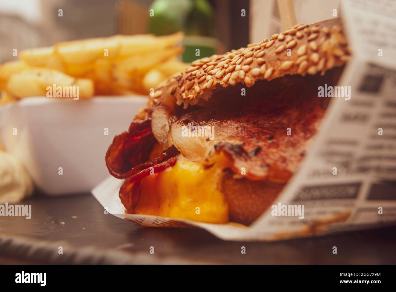 Craft-Hamburger mit Speck und pommes Frites-Chips und knuspriger Bun-Nahaufnahme - selektiver Fokus, Vintage-Filter Stockfoto