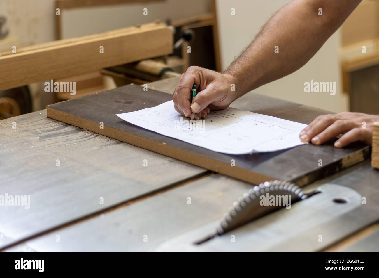 Zimmermann Holzarbeiter schneidet Holz mit industriellen elektrischen Holzschneidemaschine für die Möbelherstellung in der Werkstatt Stockfoto