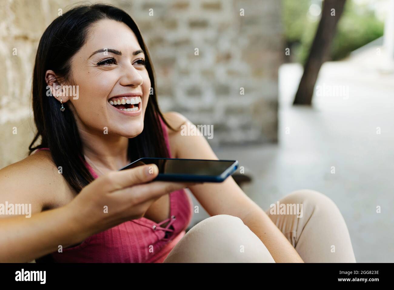 Junge trendige Frau, die Sprachnachrichten sendet oder Audio-sms auf dem Mobiltelefon aufnimmt Stockfoto