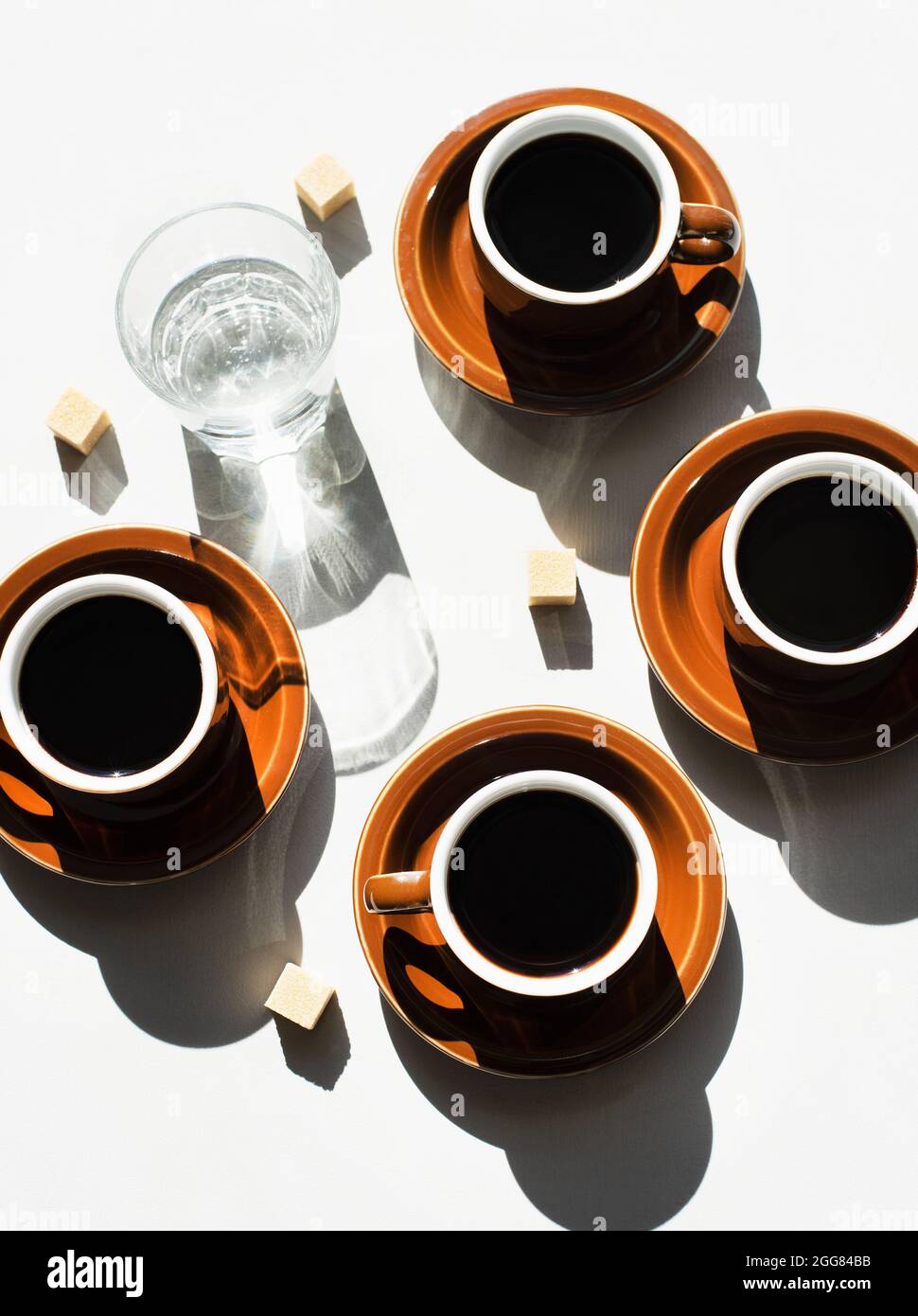 Blick von oben auf Espressotassen und ein Glas Wasser Stockfoto