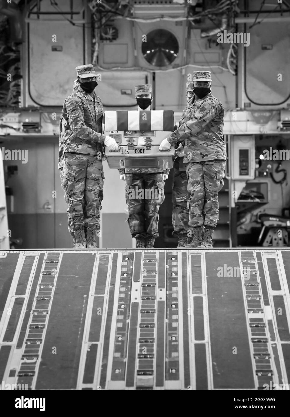 Ein US Air Force Carry-Team trägt während der nächtlichen Schulung des Air Force Mortuary Affairs Operations am Dover Air Force Base, Delaware, 30. März 2021, einen Fall für den Transfer von Trainingseinheiten. Die während des Trainings verwendeten Transferfälle werden gewichtet, um einen gefallenen Servicemitglied mit voller Schutzausrüstung zu simulieren. (USA Luftwaffe Foto von Senior Airman Christopher Quail) Stockfoto