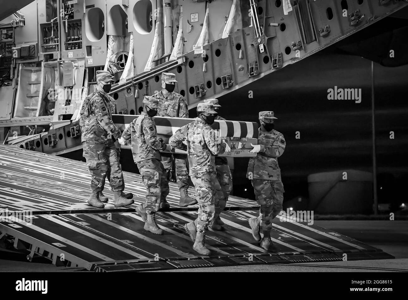 Ein US Air Force Carry-Team trägt während der nächtlichen Schulung des Air Force Mortuary Affairs Operations am Dover Air Force Base, Delaware, 30. März 2021, einen Fall für den Transfer von Trainingseinheiten. Die während des Trainings verwendeten Transferfälle werden gewichtet, um einen gefallenen Servicemitglied mit voller Schutzausrüstung zu simulieren. (USA Luftwaffe Foto von Airman 1st Class Stephani Barge) Stockfoto