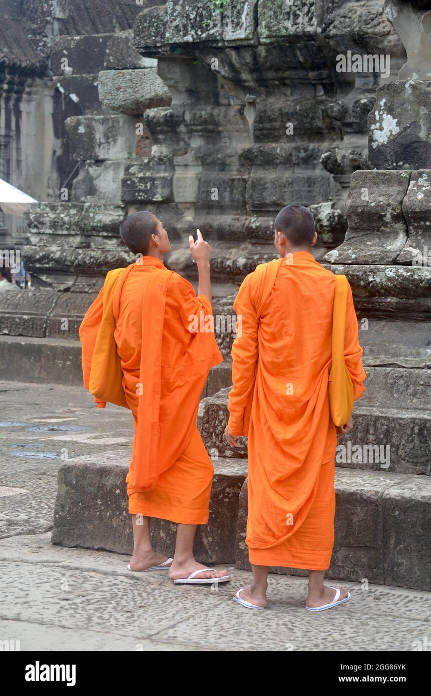 ANKOR WAT, KAMBODSCHA - 30. Jun 2014: Eine vertikale Aufnahme von zwei jungen Mönchen, die in der Nähe von Stufen in Ankor Wat, Kambodscha, stehen Stockfoto