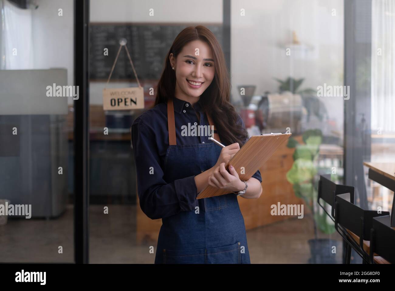 Porträt einer schönen Barista mit Tablet in ihrem Café. Small Business Owner Konzept. Stockfoto