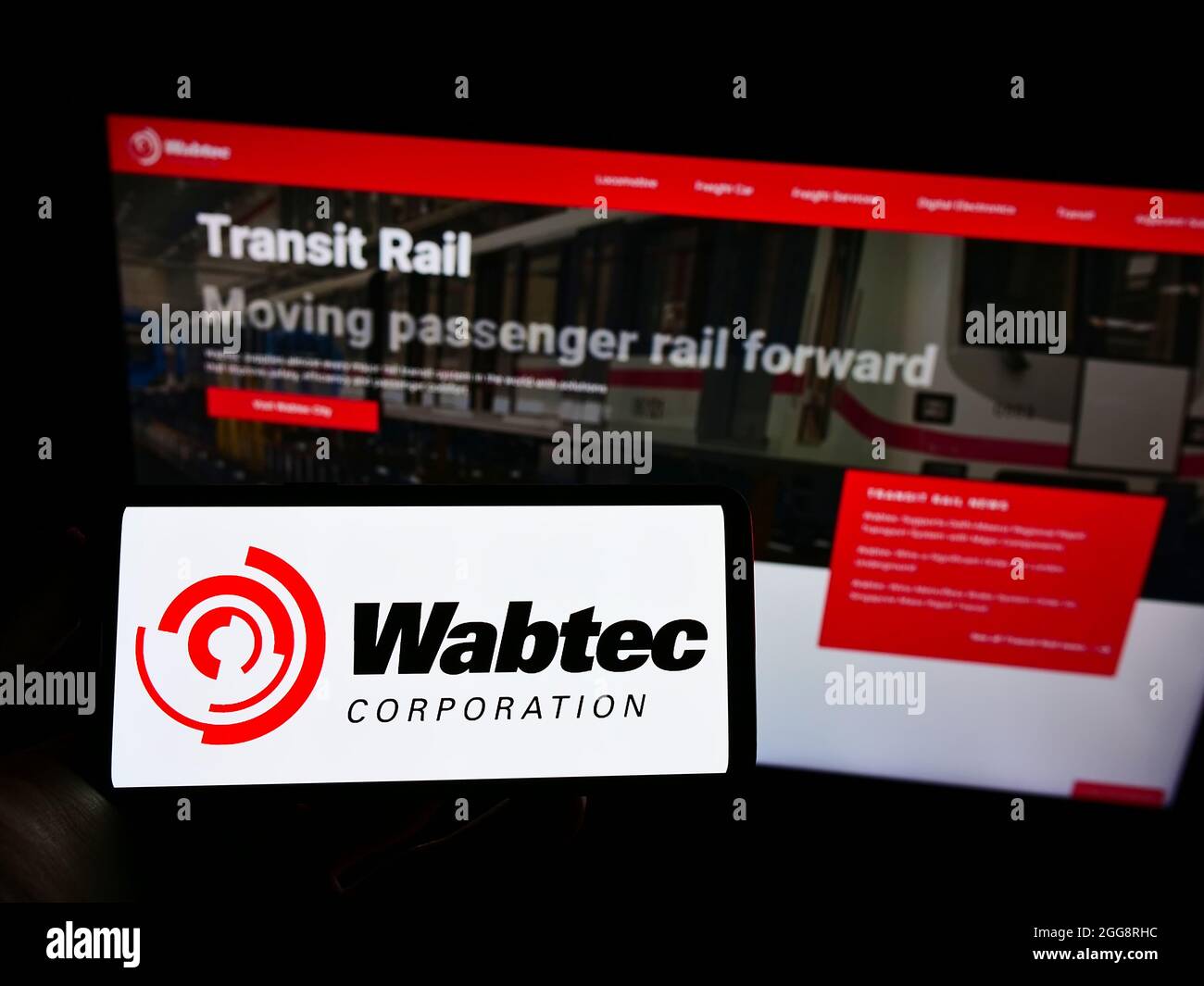 Person, die Mobiltelefon mit dem Logo des US-Eisenbahnherstellers Wabtec Corporation auf dem Bildschirm vor der Business-Webseite hält. Konzentrieren Sie sich auf die Telefonanzeige. Stockfoto