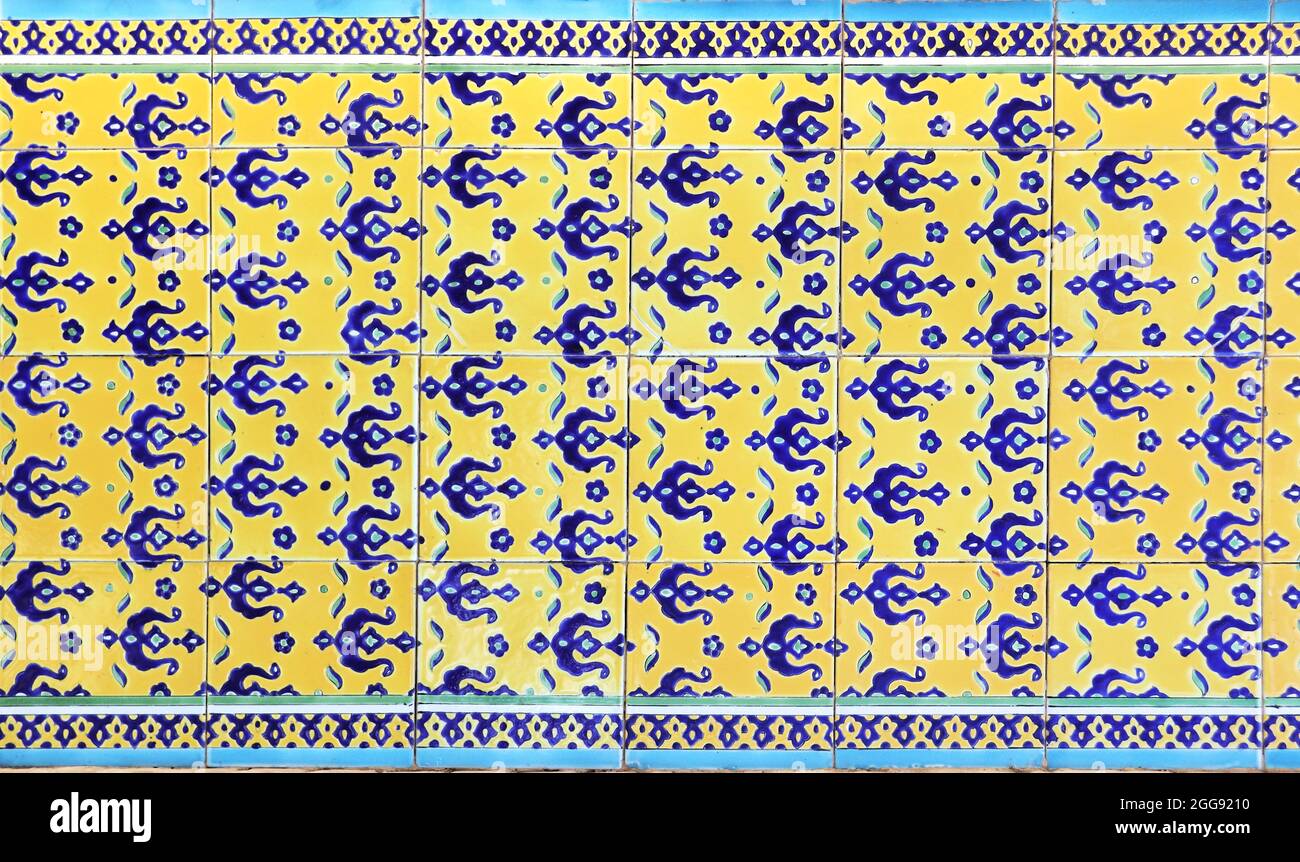 Detail der traditionellen persischen Wand mit dekorativem Ornament aus blauen und gelben Farben auf Fliesen, Iran Stockfoto