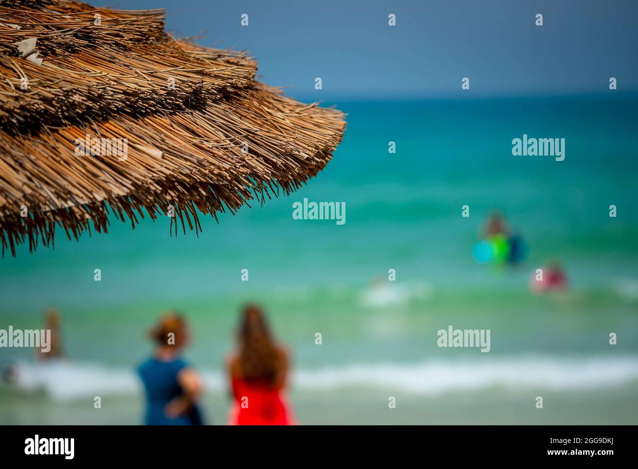 Weichzeichner Foto von einem Strand. Menschen verbringen Zeit auf der Meeresküste. Sommerurlaub Konzeptioneller Hintergrund. Stockfoto