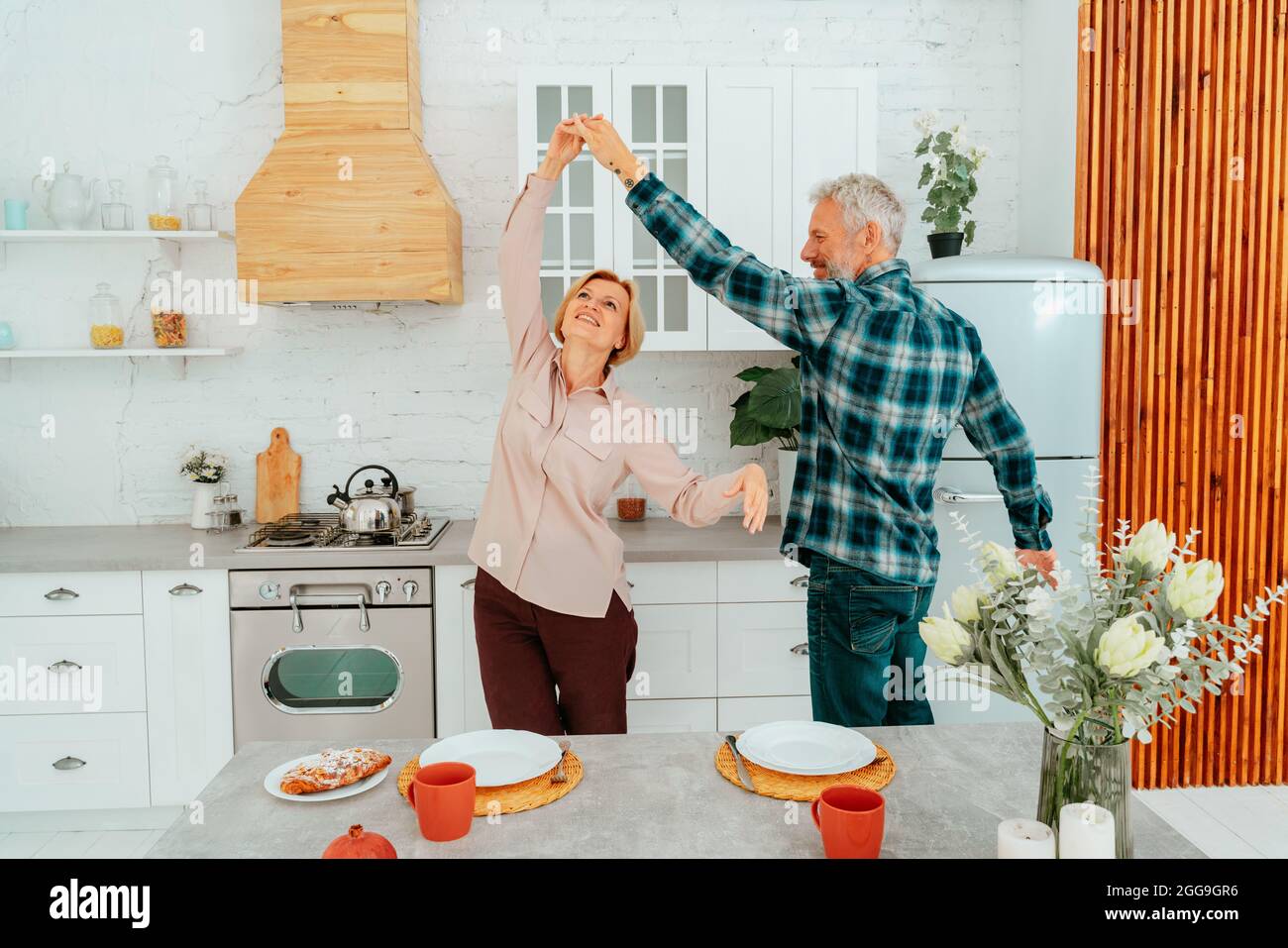 Mann und Frau tanzen zu Hause während des Frühstücks Stockfoto