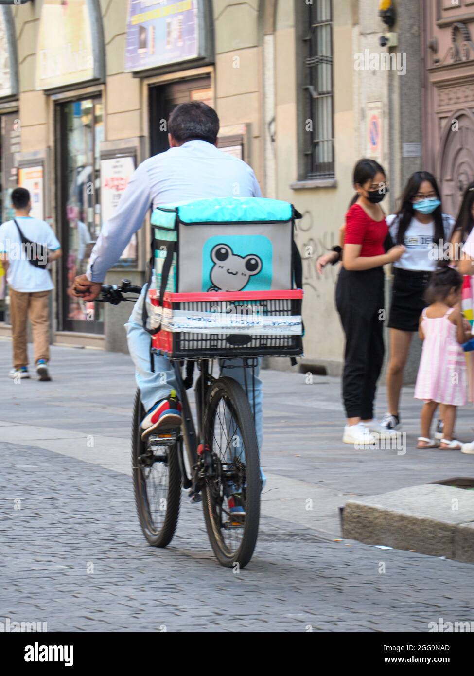 MAILAND, ITALIEN - 09. Aug 2021: Rückansicht eines Fahrers, der Lebensmittel liefert, die über eine App der Lieferfirmen in Mailand, Italien, bestellt wurden Stockfoto