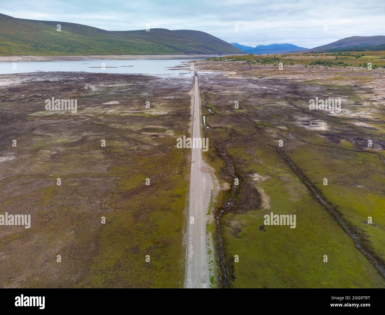 Garve, Schottland, Großbritannien. 30. August 2021.der niedrige Wasserstand im Stausee von Loch Glascarnoch bei Garve hat bisher verborgene Strukturen enthüllt, darunter eine alte Straße, eine Brücke und Telegrafenmasten. Die alte Straße war die Hauptroute von Ullapool nach Dingwall, bis die aktuelle neue Straße neben dem Stausee gebaut wurde. Der Stausee in Glen Glascarnoch wurde in den 1950er Jahren als Teil des Wasserkraftwerks Conon gegründet. Iain Masterton/Alamy Live News. Stockfoto