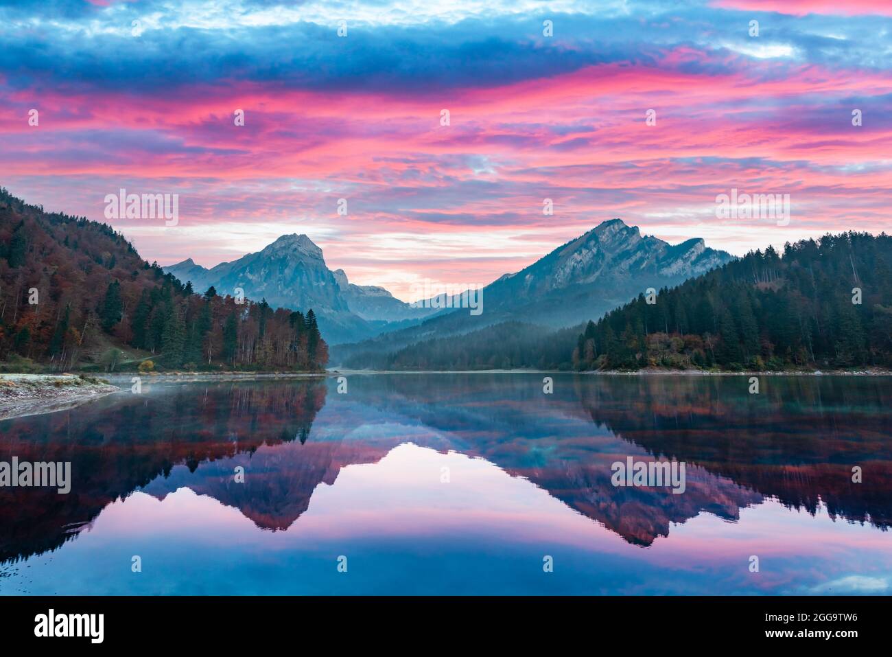 Ruhiger Herbstblick auf den Obersee in den Schweizer Alpen. Dramatischer Sonnenuntergang Himmel und Berge Spiegelungen in klarem Wasser. Nafels Dorf, Schweiz. Landschaftsfotografie Stockfoto